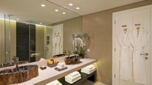 grosses edles sauberes badezimmer im modernen stil mit viel glas und spiegeln die waschbecken sind aus grossen stein geschliffen es gibt viele handtücher und pflegeprodukte dazu zwei bademäntel im luxuriösen hochklassigen exklusiven designer hotel santa m